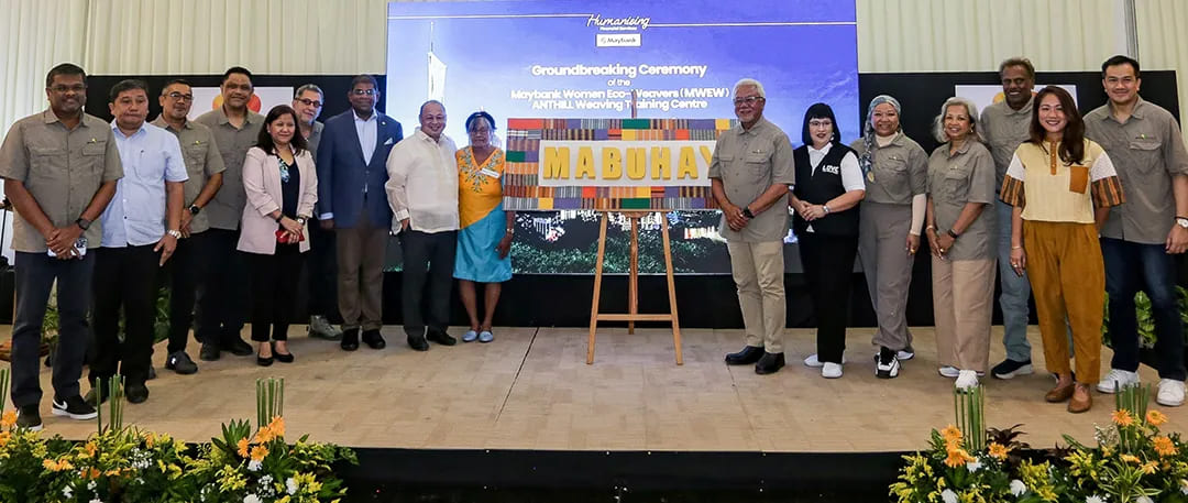 Tan Sri Dato’ Sri Ir. Zamzamzairani Mohd Isa, Chairman of Maybank Group & Foundation, Madam Lauriana Olaguir, master weaver, and Guests of Honour posing in front of a vibrant tapestry with 'MABUHAY' woven by ANTHILL women weavers using zero-waste fabric, symbolising community and cultural pride.