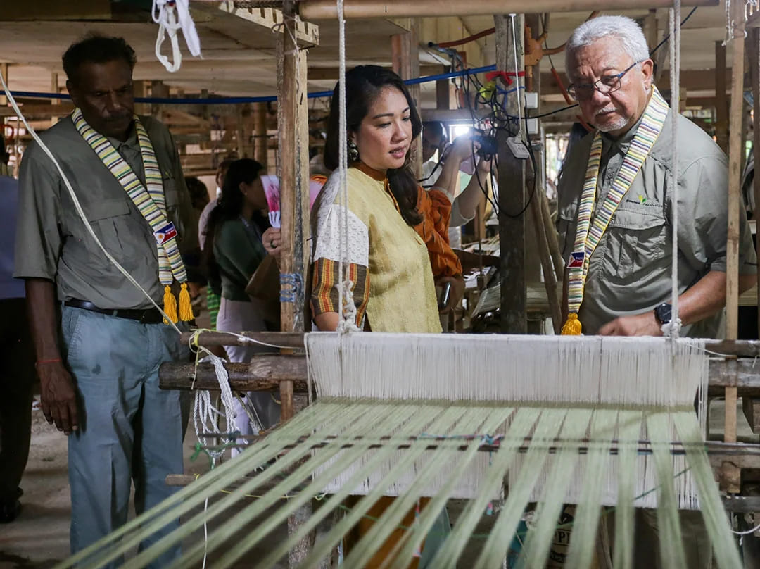 Tan Sri Dato’ Sri Ir. Zamzamzairani Mohd Isa, Chairman of Maybank Group and Foundation, observes a traditional loom demonstration by Ms. Anya Lim, Co-Founder of ANTHILL Fabric Gallery, while Datuk Karunakaran, Maybank Foundation Trustee, looks on.